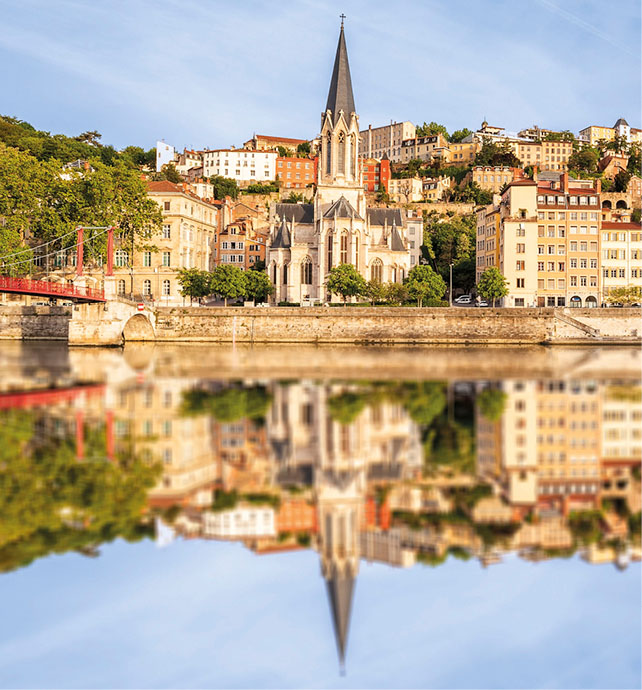 Reflection on the water of the Rhone river of the spire of a building in Lyon
