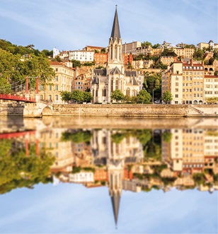 Reflection on the water of the Rhone river of the spire of a building in Lyon