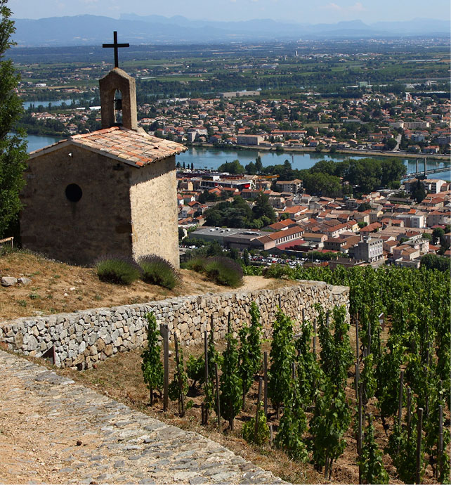 a church at the peak of a hill overlooking the town of Tournon and the Rhone river