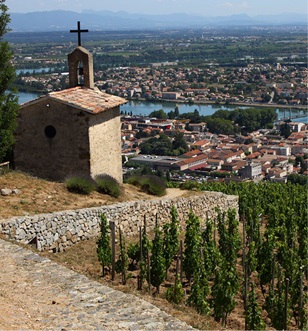 a church at the peak of a hill overlooking the town of Tournon and the Rhone river