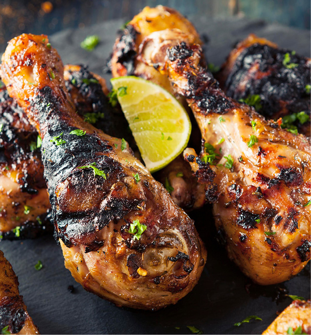 dish of food, grilled chicken drumsticks with chargrilled skin, parsley garnish and lime wedge