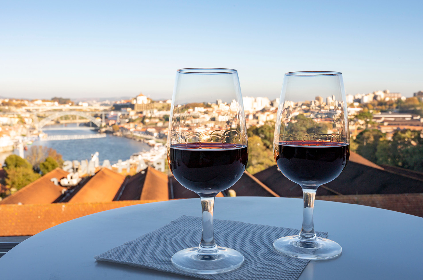 Two glasses of red wine overlooking Porto on the Douro River in Portugal