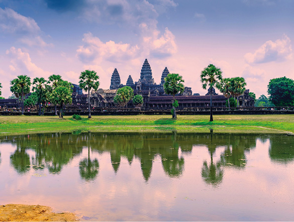 Angkor Wat temple at sunrise, with the trees reflected in the water