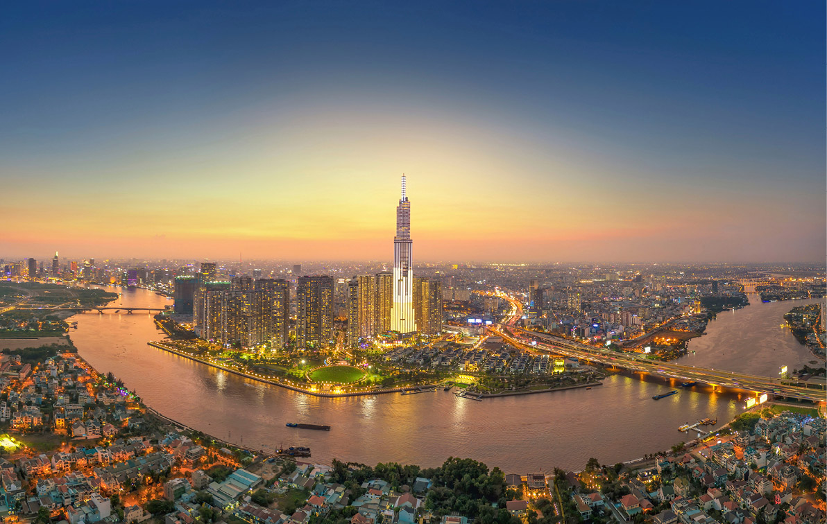 Evening view of Ho Chi Minh City and the Mekong River in Vietnam, with the buildings all lit up and glowing