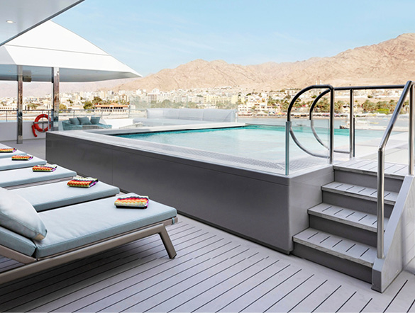 A guest enjoying swimming in the infinity-style pool on board a luxury yacht cruise 