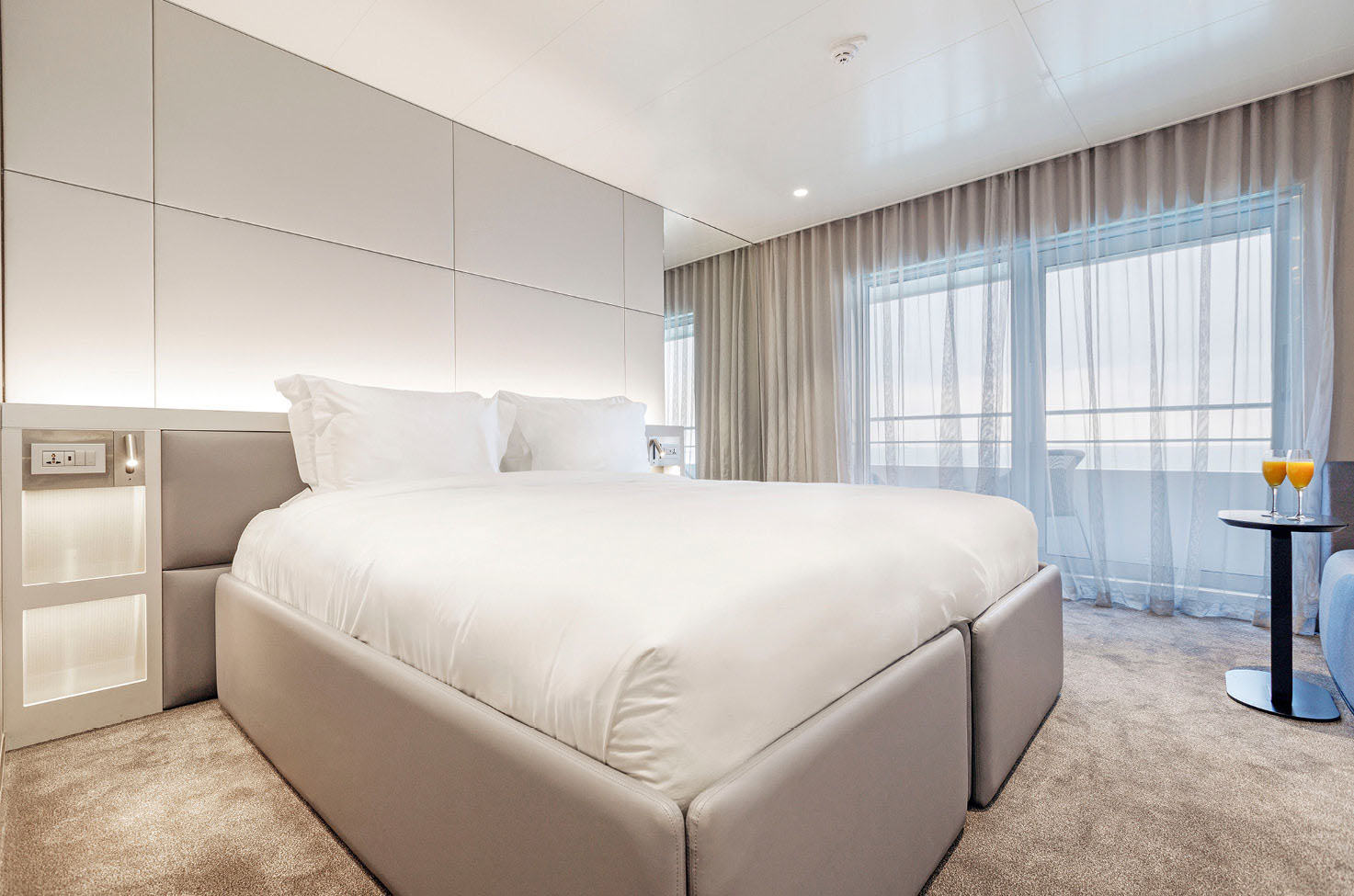 A spacious and bright cabin with balcony on board a luxury yacht cruise